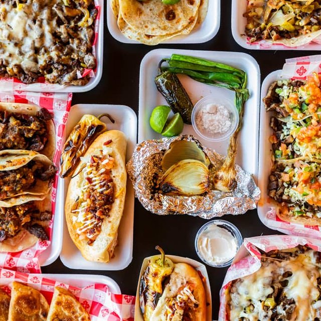 A full spread of tacos, tortas, and grilled toppings